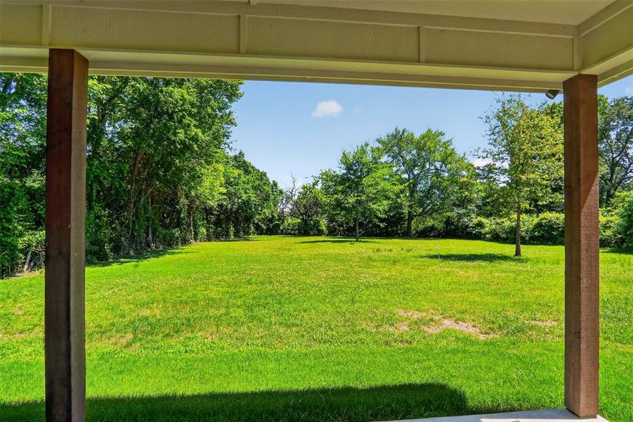Expansive green lawn framed by mature trees, offering a significant outdoor space Expansive green lawn framed by mature trees, offering a significant outdoor space