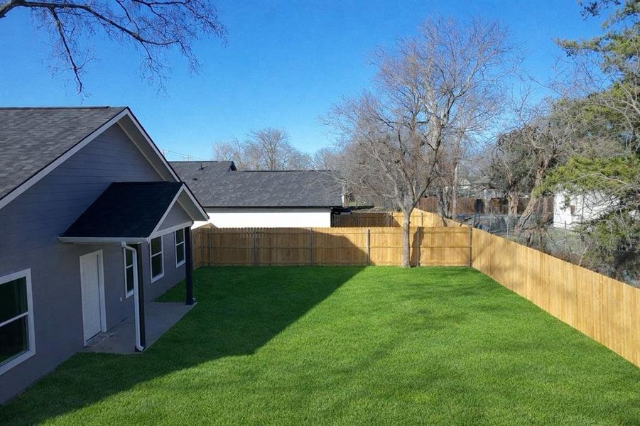 Fenced backyard with a patio area Fenced backyard with a patio area