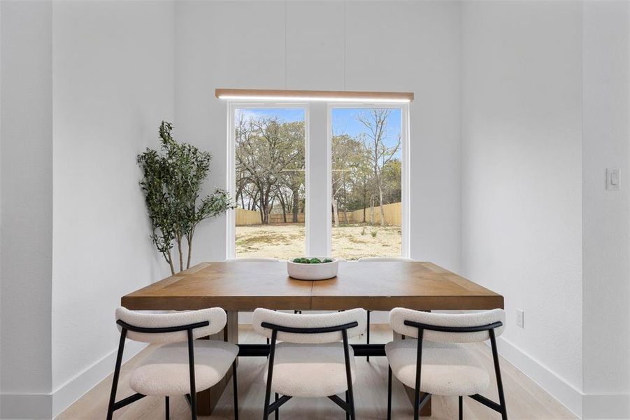 Dining space with light wood finished floors and baseboards