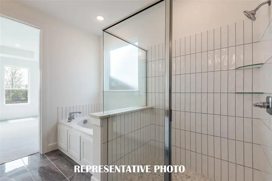This owner's bath is the perfect place to soak your cares away or relax in the oversized walk in shower.  REPRESENTATIVE PHOTO