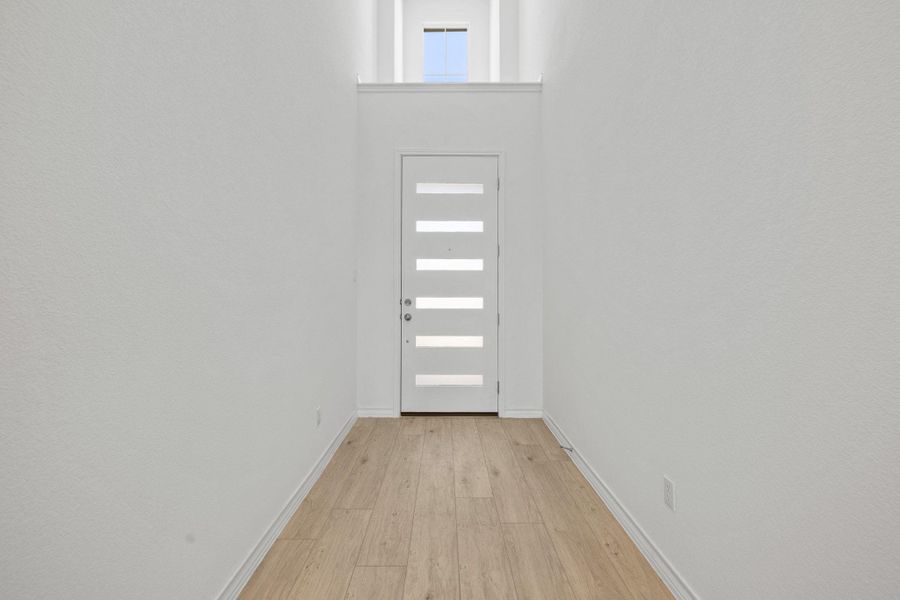 Doorway featuring wood finished floors and a high ceiling