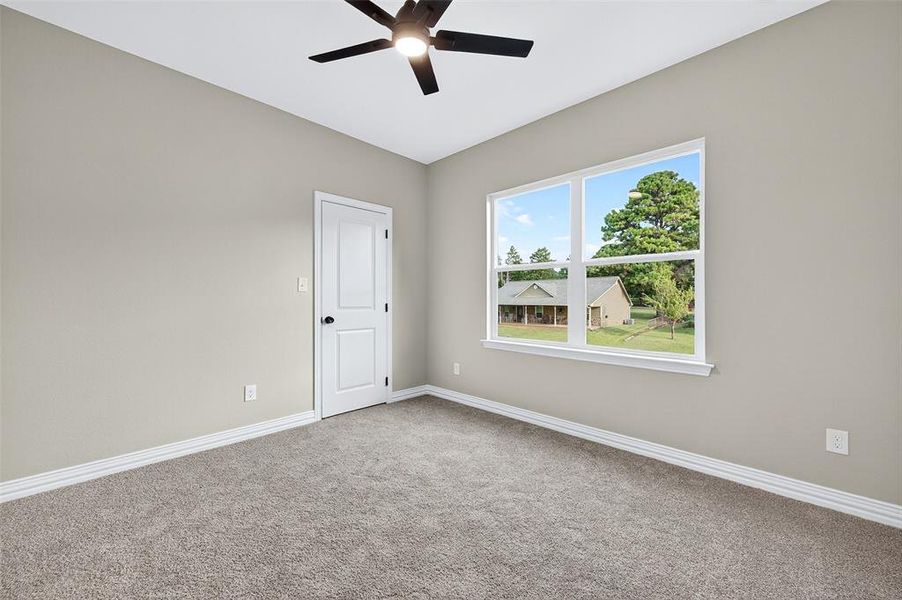 Carpeted empty room featuring baseboards and ceiling fan Carpeted empty room featuring baseboards and ceiling fan