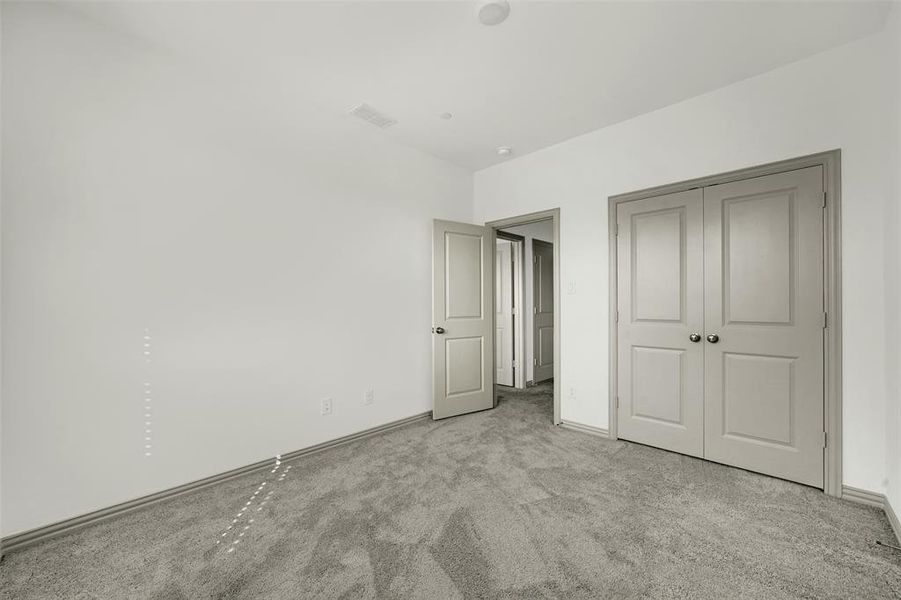 Unfurnished bedroom with carpet floors and a closet Unfurnished bedroom with carpet floors and a closet