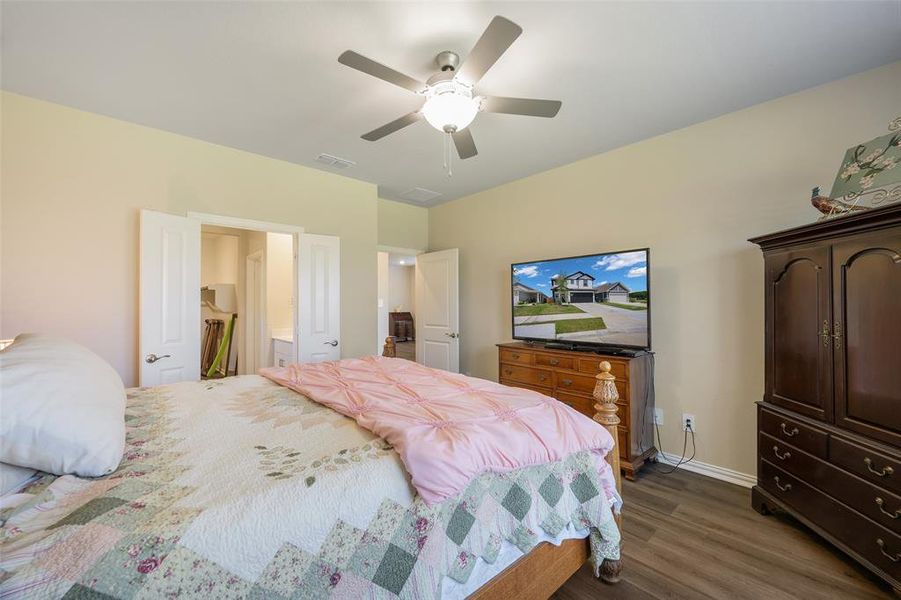 Spacious room featuring wood-finish flooring and a ceiling fan with integrated lighting Spacious room featuring wood-finish flooring and a ceiling fan with integrated lighting