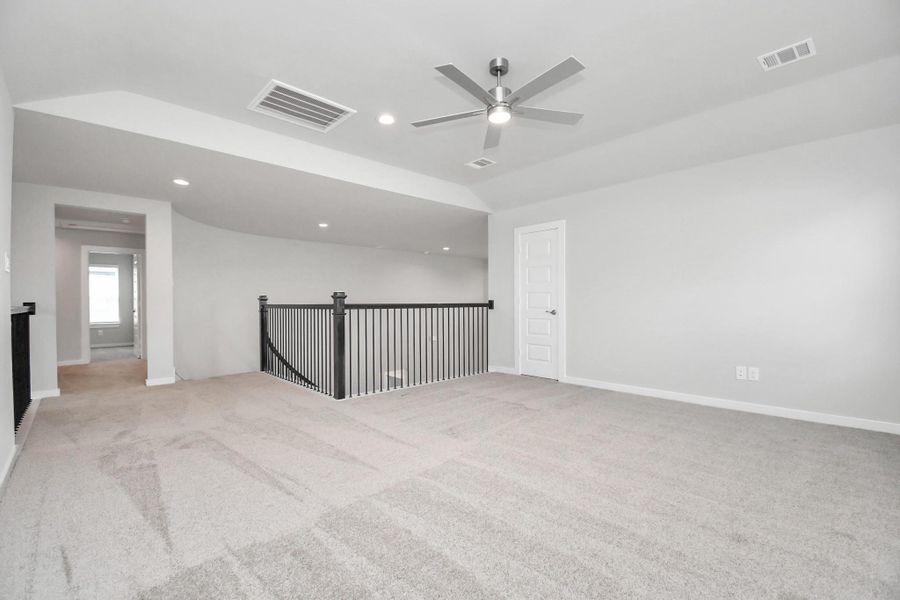 Ascend to relaxation in this fantastic game room! Ideal for both casual gatherings and adult gaming, it boasts plush carpet, lofty ceilings, custom paint, and ample windows for abundant natural light. Sample photo of completed home with similar floor plan. Actual colors and selections may vary.