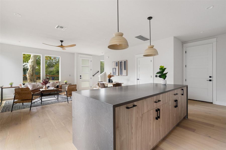 Kitchen with light wood-style floors, a kitchen island, pendant lighting, modern cabinets, and recessed lighting Kitchen with light wood-style floors, a kitchen island, pendant lighting, modern cabinets, and recessed lighting