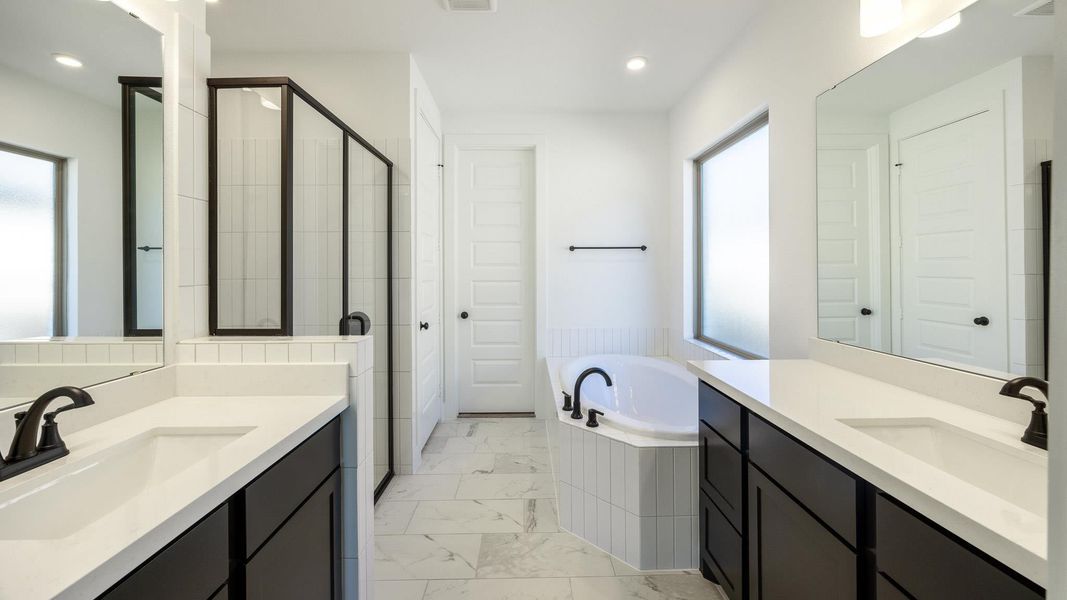 Bathroom with a shower stall, a bath, two vanities, light marble finish flooring, and recessed lighting