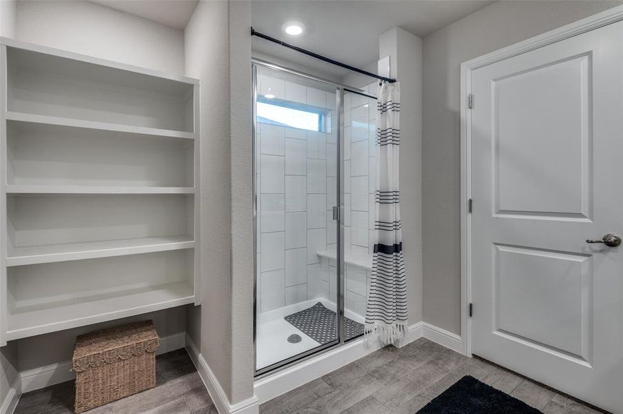 Full bathroom with a stall shower and light wood-type flooring
