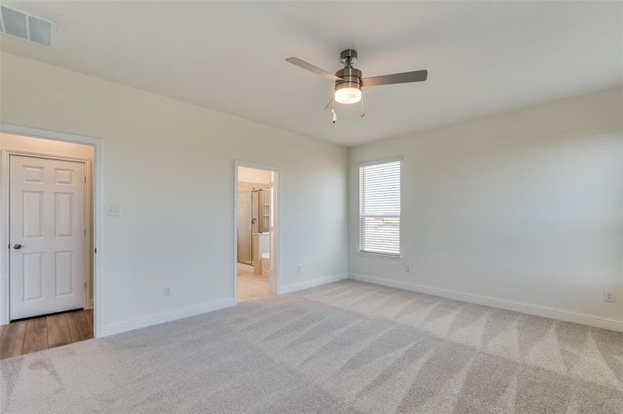 Spare room featuring light colored carpet and ceiling fan