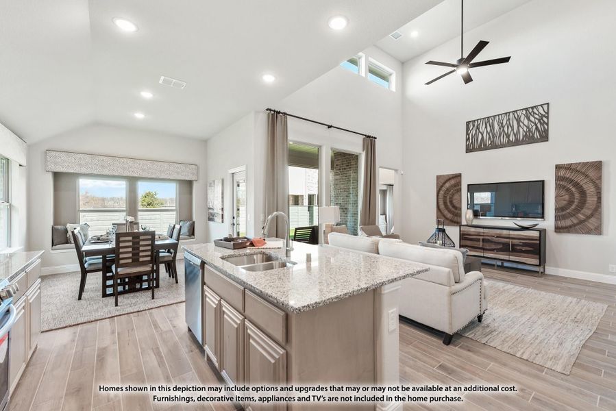 Open-concept living area with kitchen island, dining space, and vaulted ceiling with ceiling fan