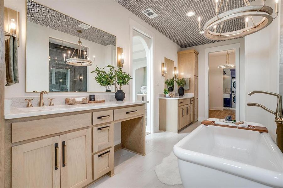 Full bathroom with a chandelier, vanity, a soaking tub, light tile patterned floors, and a stall shower
