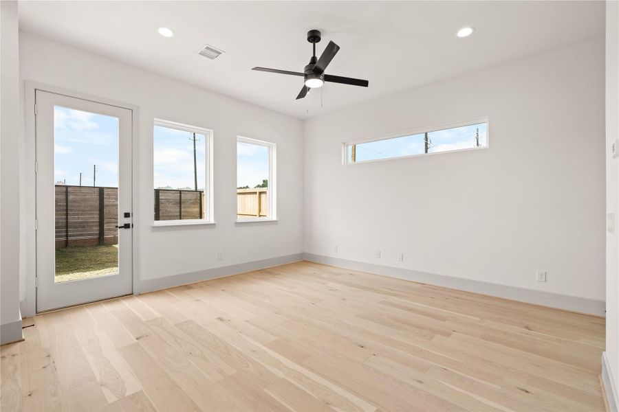 Living room with engineered wood floors, ceiling fan, and French door to the backyard Living room with engineered wood floors, ceiling fan, and French door to the backyard