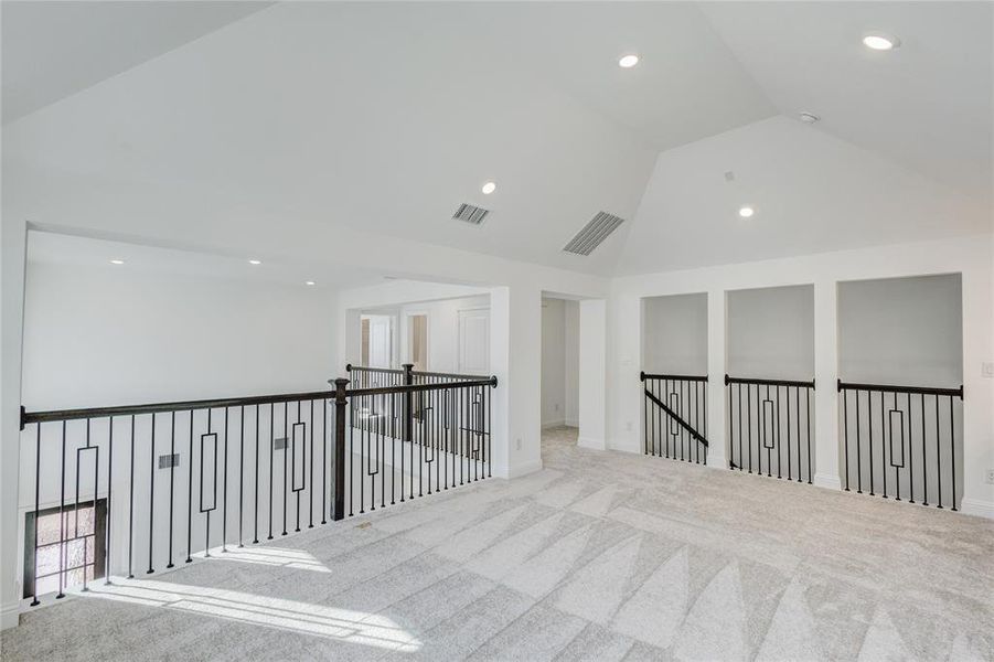 Carpeted empty room featuring lofted ceiling