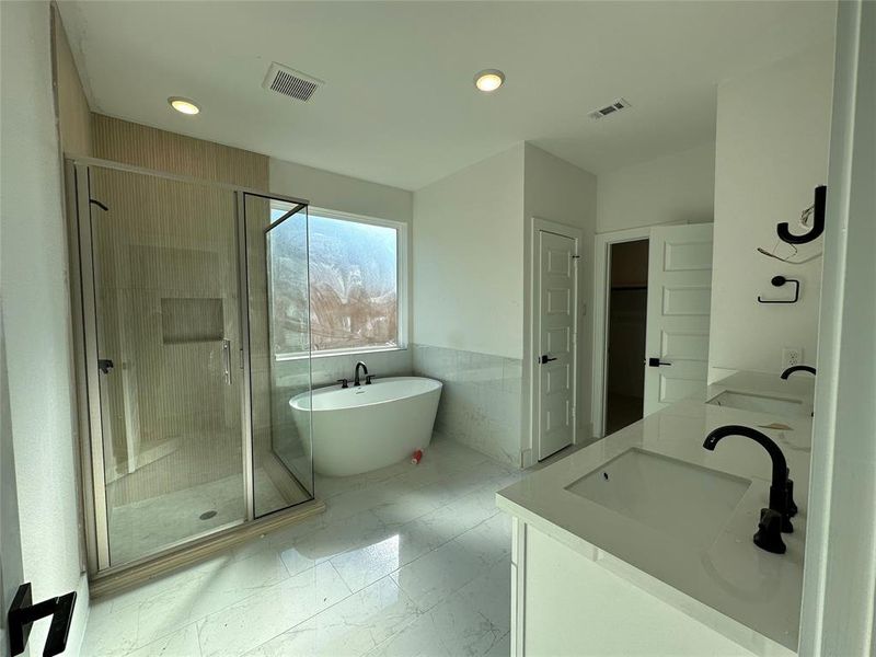 Calm and inviting primary bathroom with a freestanding tub, designed for simple relaxation.