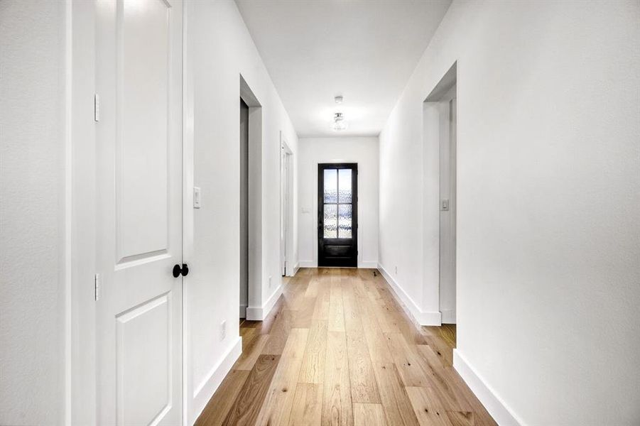 Corridor with baseboards and light wood finished floors