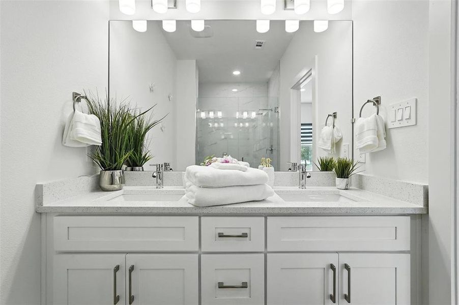Bathroom featuring a stall shower and double vanity