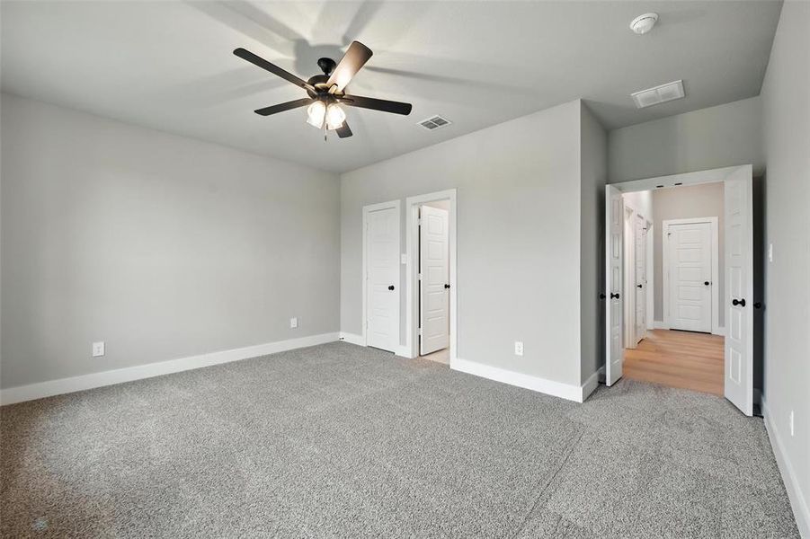 Unfurnished bedroom featuring carpet flooring and a ceiling fan Unfurnished bedroom featuring carpet flooring and a ceiling fan