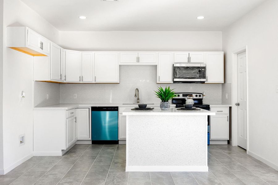 Chic kitchen featuring white cabinetry, stainless steel appliances, and a central island—perfect for meal preparation and entertaining guests Chic kitchen featuring white cabinetry, stainless steel appliances, and a central island—perfect for meal preparation and entertaining guests