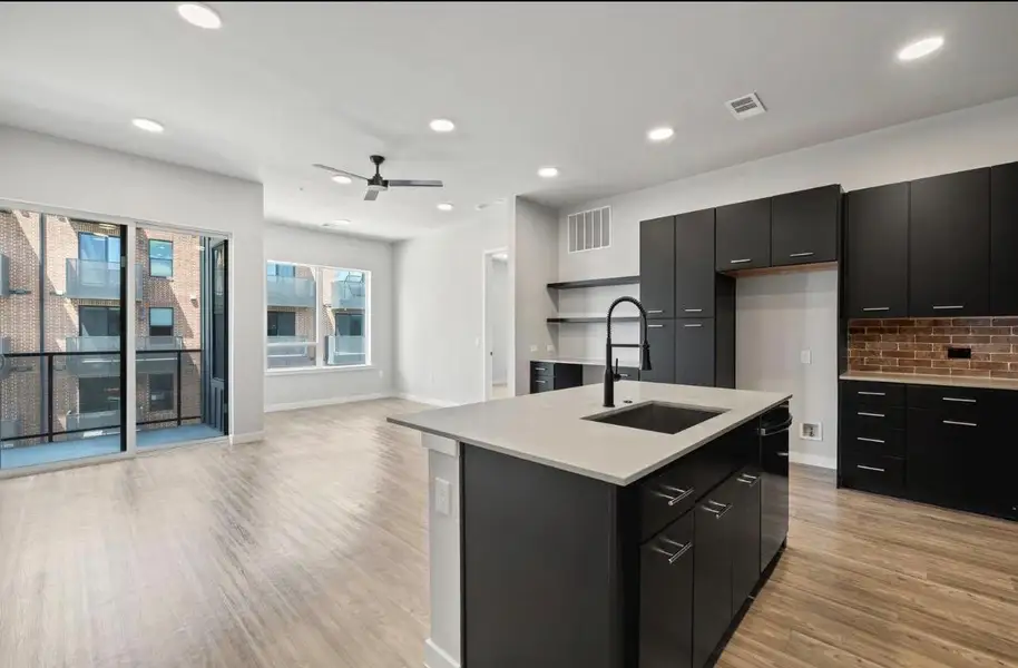 Clean lines and wood flooring define this open layout integrating the kitchen and living space. Clean lines and wood flooring define this open layout integrating the kitchen and living space.