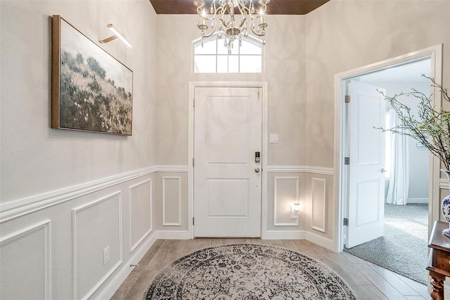 Foyer with an inviting chandelier and a decorative wall