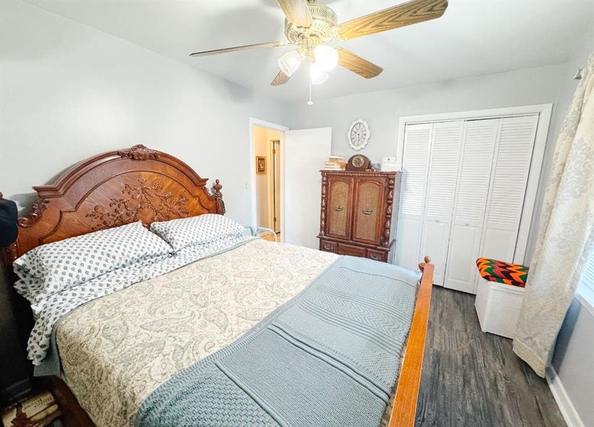Bedroom featuring dark wood-style flooring, a closet, and a ceiling fan