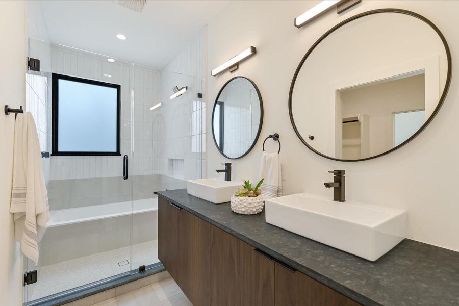 Bathroom featuring a stall shower, double vanity, tile patterned floors, and recessed lighting