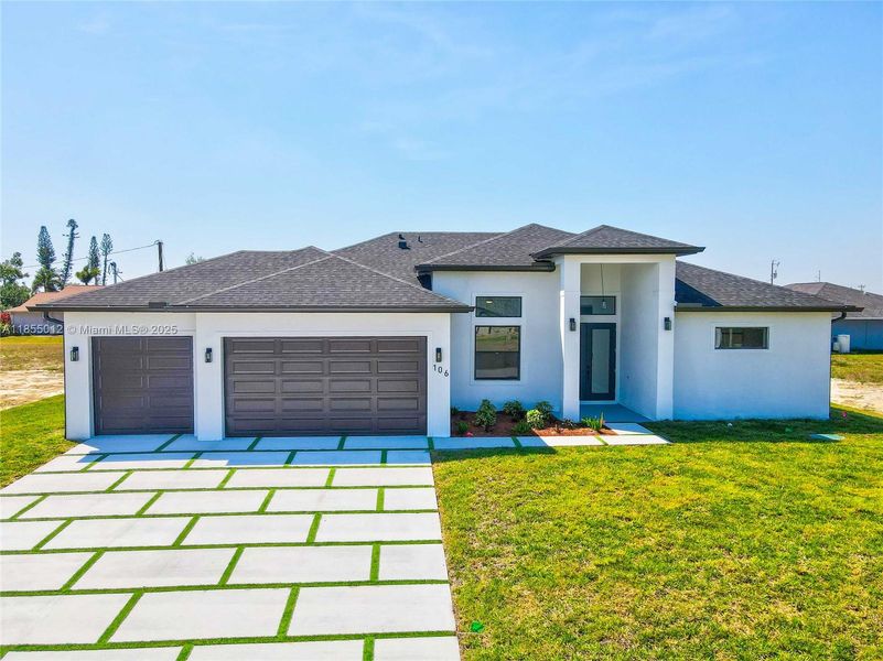 Luxurious home with a front lawn, driveway, and a 3 car garage