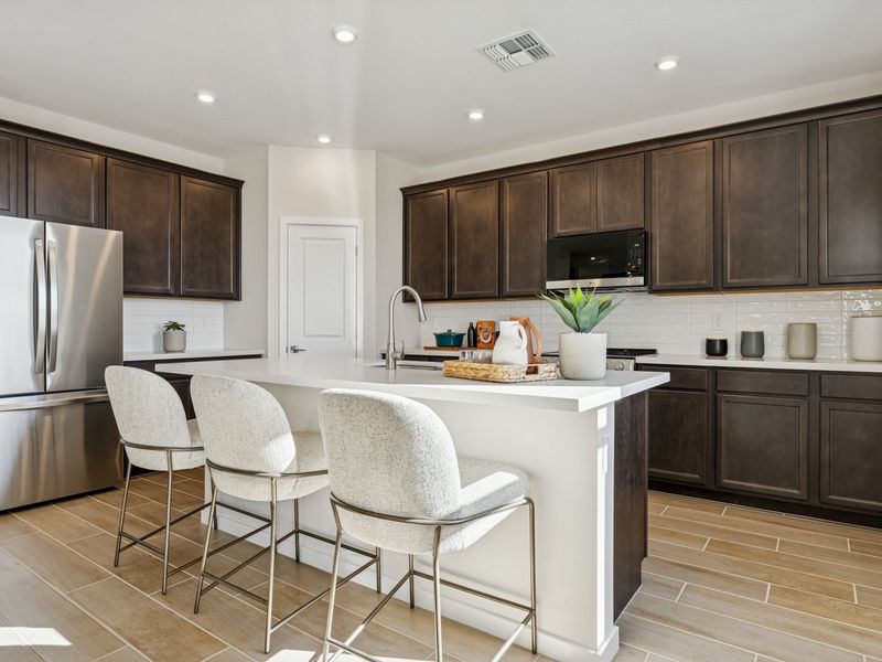 A kitchen with a white table and chairs. A kitchen with a white table and chairs.