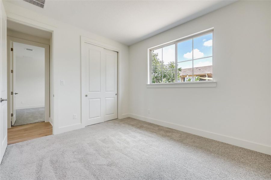 Unfurnished bedroom featuring light carpet and a closet