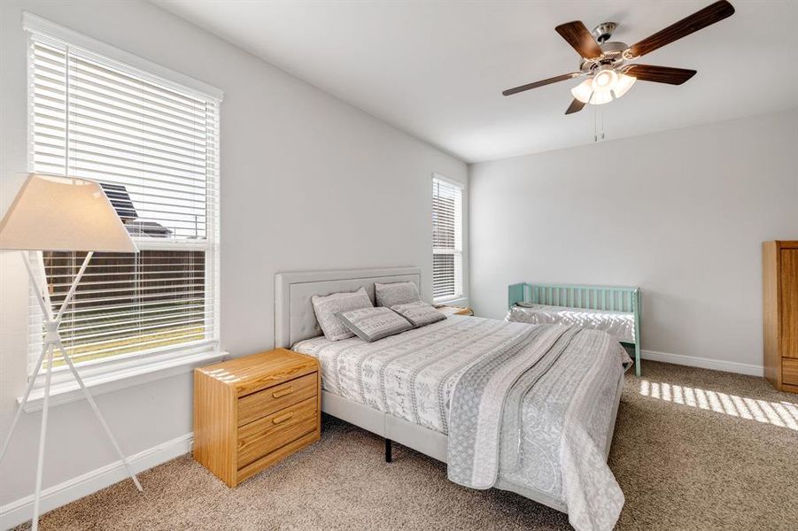 Bedroom with light carpet and ceiling fan