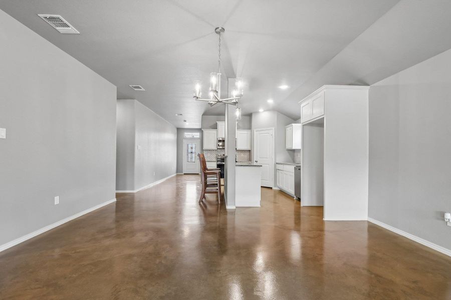 An open concept living area seamlessly flows into a kitchen featuring modern amenities and polished flooring. An open concept living area seamlessly flows into a kitchen featuring modern amenities and polished flooring.