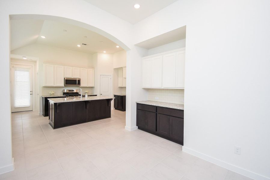 The dark/light contrast in cabinet and counter finishes is rich and striking, as we enter the dining space (with marvelous built in cabinetry, comprising a butler's panty, perhaps), and on to a dream kitchen.