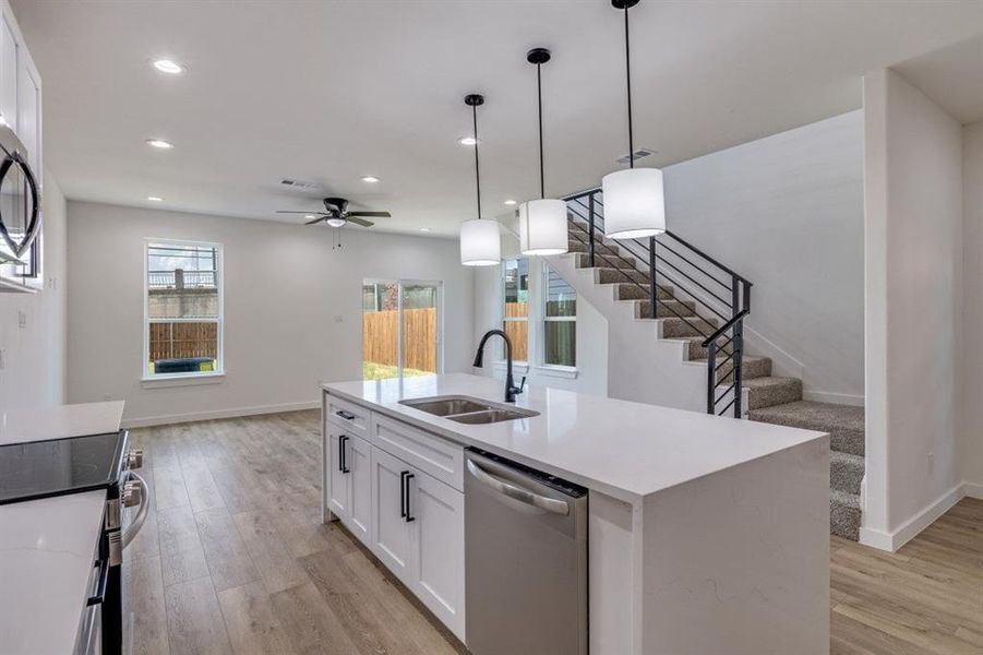 Kitchen with white cabinetry, pendant lighting, appliances with stainless steel finishes, light wood-style flooring, and recessed lighting Kitchen with white cabinetry, pendant lighting, appliances with stainless steel finishes, light wood-style flooring, and recessed lighting