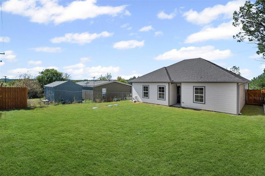 Back of property with a fenced backyard and a shingled roof Back of property with a fenced backyard and a shingled roof