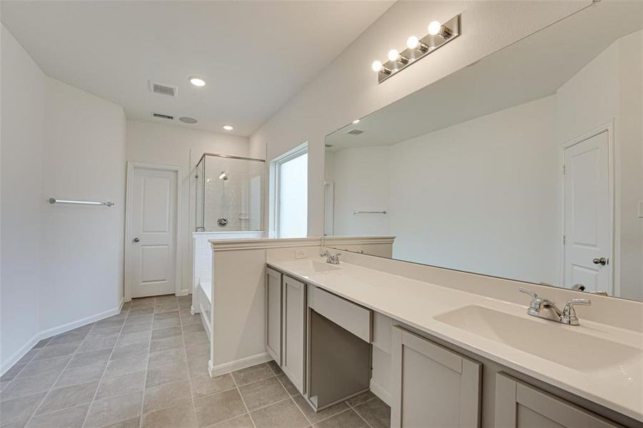 Bathroom featuring dual bowl vanity, separate shower and tub, and tile patterned flooring