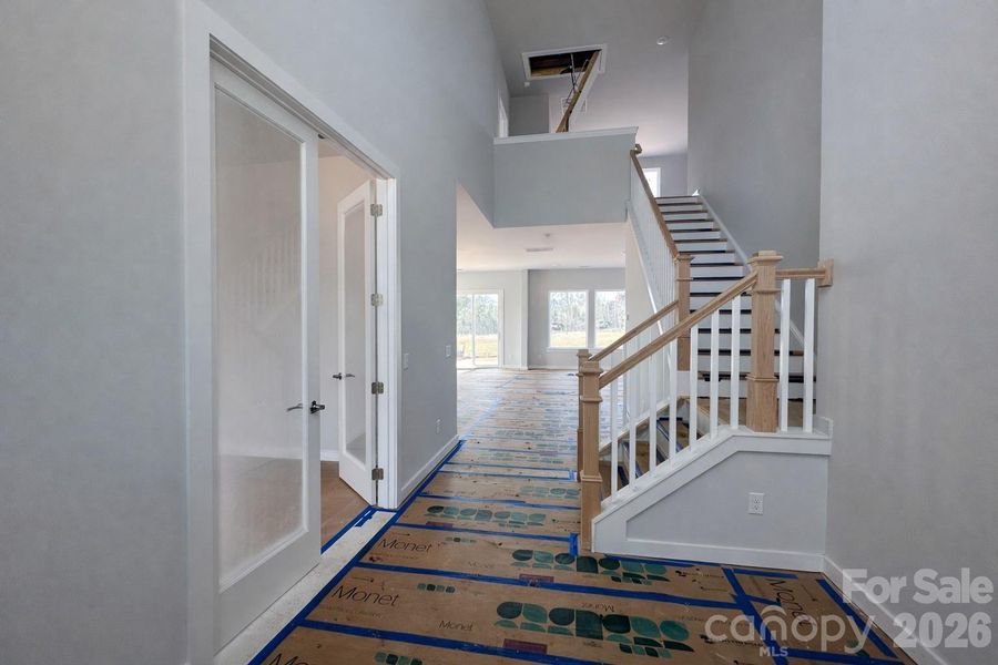 Welcoming 2-Story Foyer with Private Study & Waterfall Stairs Welcoming 2-Story Foyer with Private Study & Waterfall Stairs