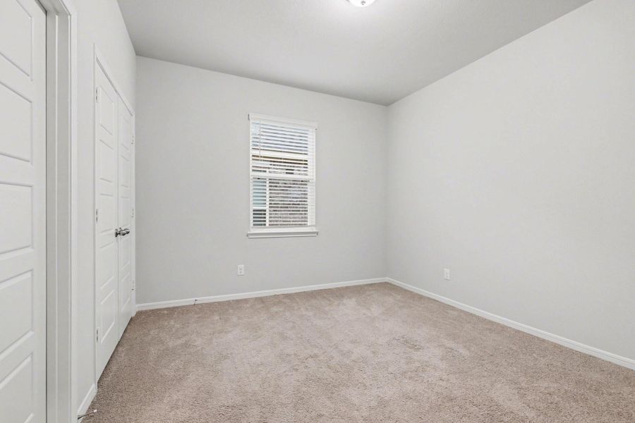 Secondary bedroom with carpet flooring, closet, and window for natural light. Secondary bedroom with carpet flooring, closet, and window for natural light.