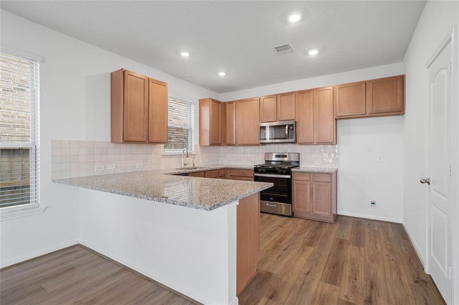 This kitchen is by far any chef’s dream! This spacious kitchen features high ceilings, stained wood cabinets, granite countertops, SS appliances, modern tile backsplash, recessed lighting, and extended counter for breakfast bar, and a pantry all overlooking your huge family room.