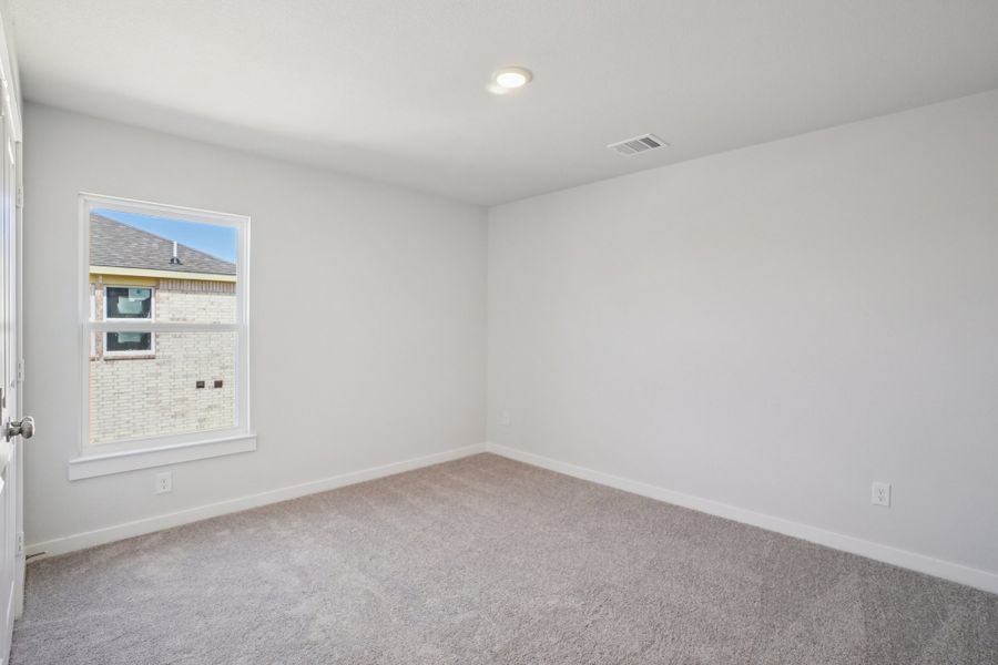 A room with a window and a carpet.