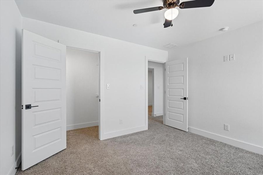 Unfurnished bedroom with light carpet and ceiling fan