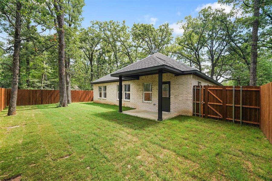 Expansive backyard featuring a manicured lawn and mature trees Expansive backyard featuring a manicured lawn and mature trees