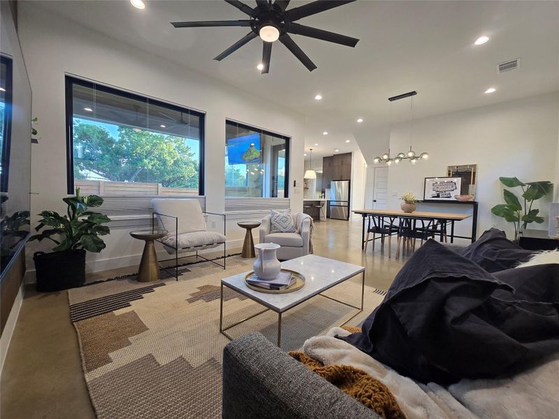 Smooth concrete floors and extensive windows define this airy open-concept living area.