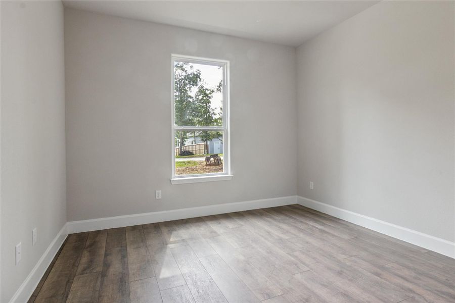 This 3rd bedroom features ample natural light from a large window, creating a bright and inviting space.