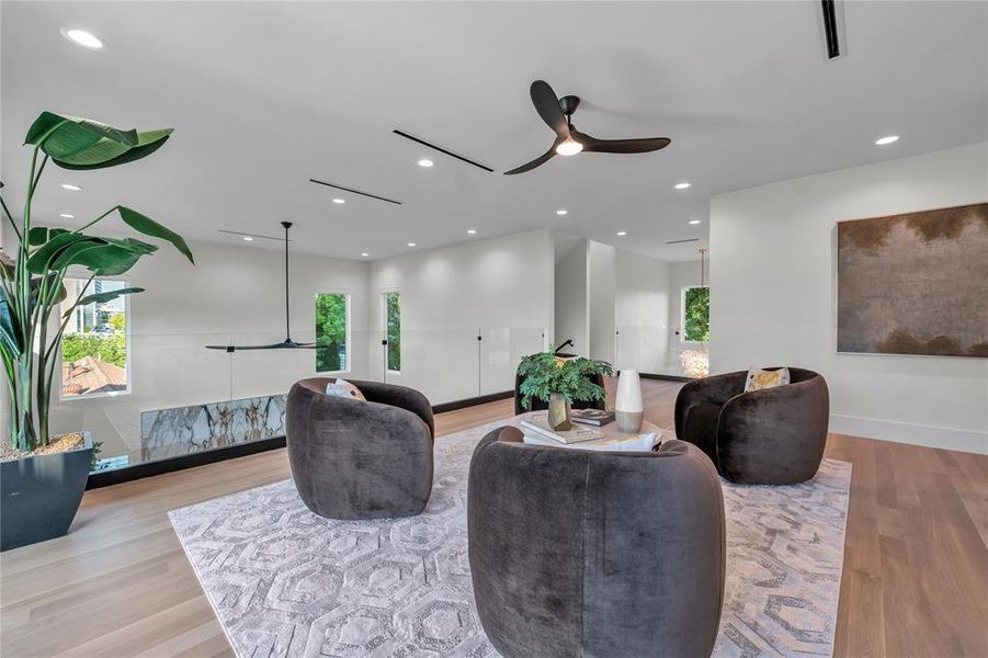 Living area featuring ceiling fan, recessed lighting, and light wood-type flooring Living area featuring ceiling fan, recessed lighting, and light wood-type flooring