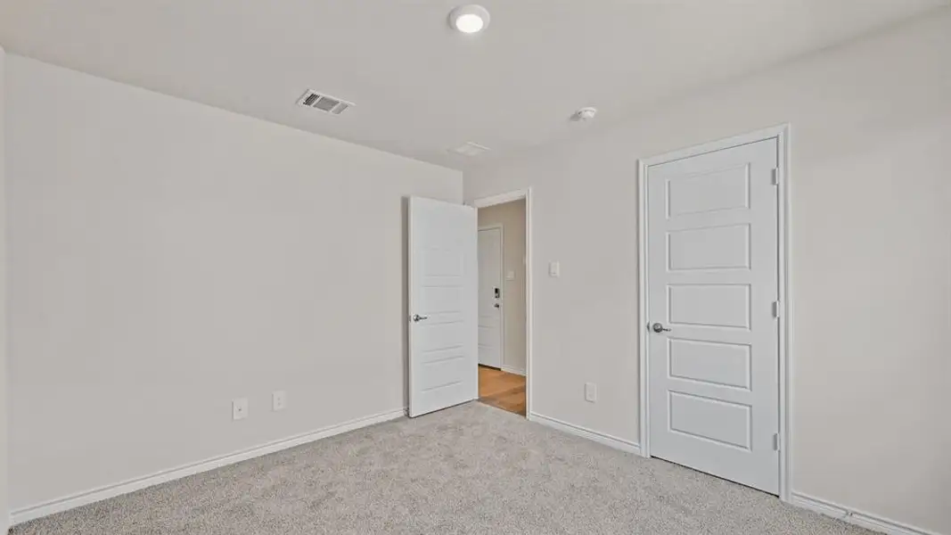 Carpeted interior space featuring light-colored walls and white trim Carpeted interior space featuring light-colored walls and white trim
