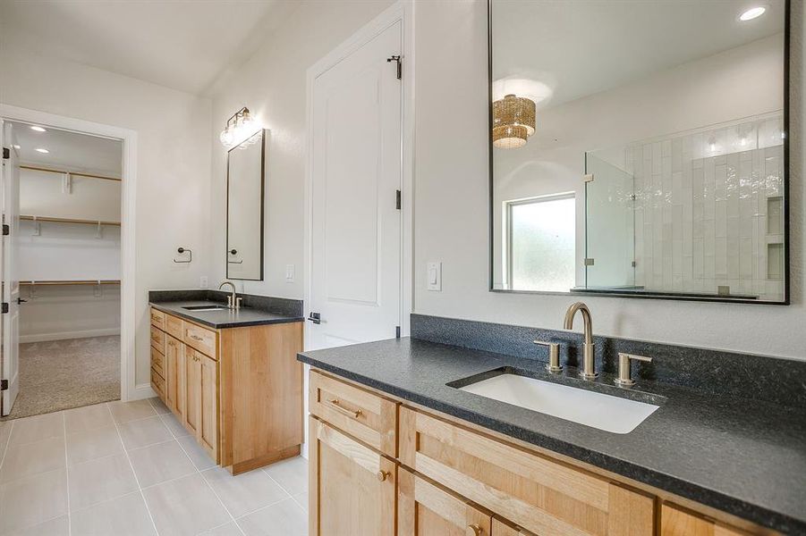 Bathroom with two vanities, recessed lighting, a spacious closet, a shower stall, and light tile patterned flooring Bathroom with two vanities, recessed lighting, a spacious closet, a shower stall, and light tile patterned flooring
