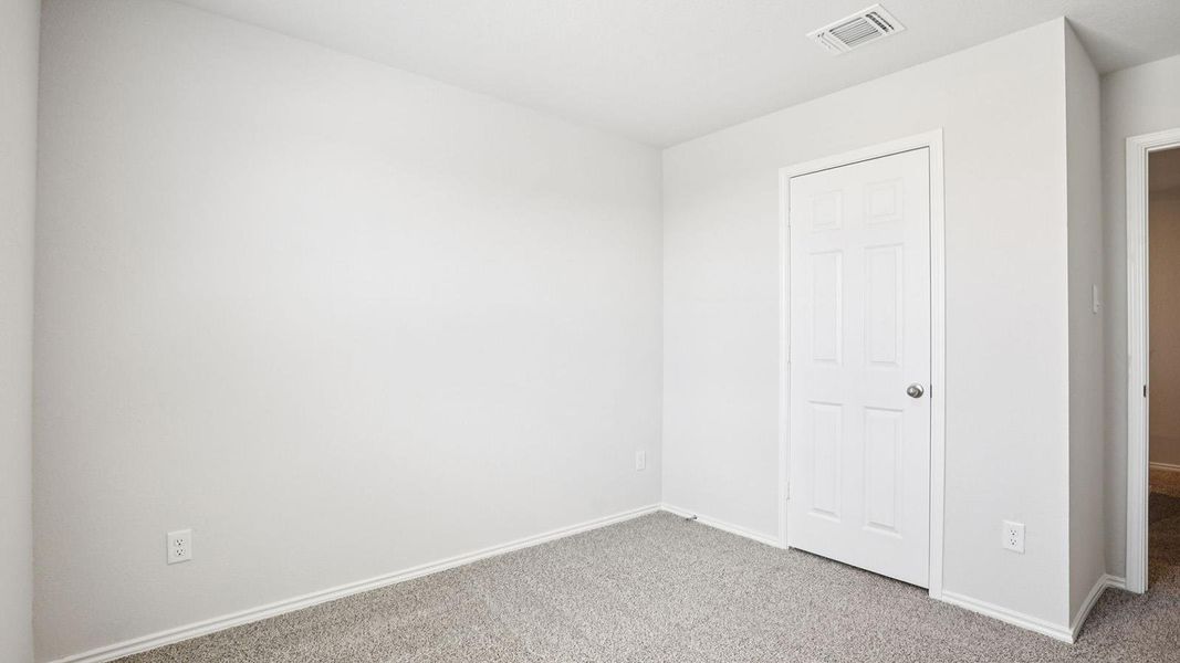 Neutral-toned walls and grey carpeting create a versatile interior