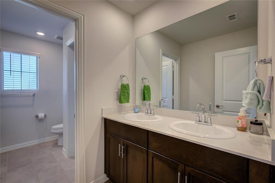 Bathroom featuring tile patterned floors, vanity, and toilet