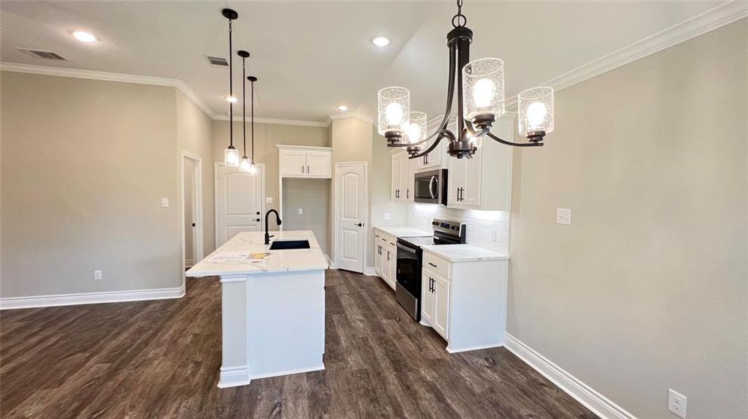Kitchen with sink, appliances with stainless steel finishes, dark hardwood / wood-style flooring, and backsplash