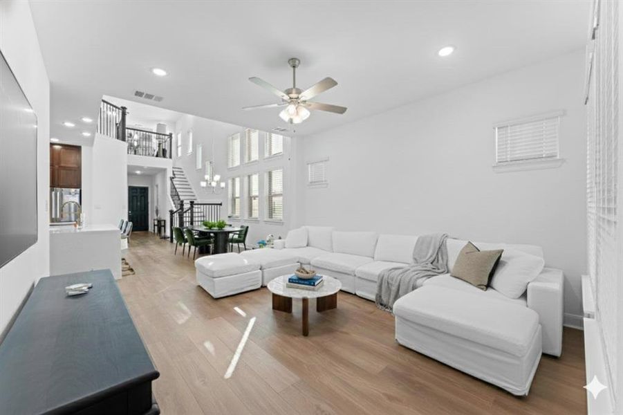 Living area with stairway, light wood-type flooring, recessed lighting, and ceiling fan Living area with stairway, light wood-type flooring, recessed lighting, and ceiling fan